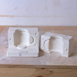 Molde para tazas, sobre una mesa de madera, elaborado en nuestro curso de moldes para cerámica