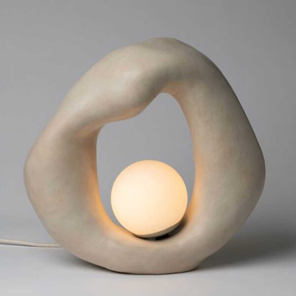 Moderna lámpara de forma orgánica con una base escultórica y una esfera luminosa central que emite una luz suave y envolvente