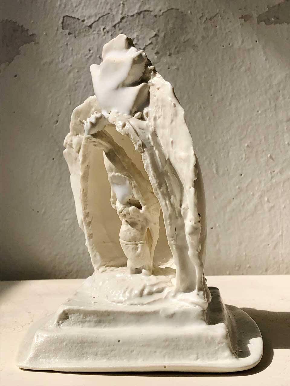 Escultura abstracta moderna de una virgen y Buda caminando juntos, simbolizando la unión de pensamientos orientales y occidentales sobre la iglesia
