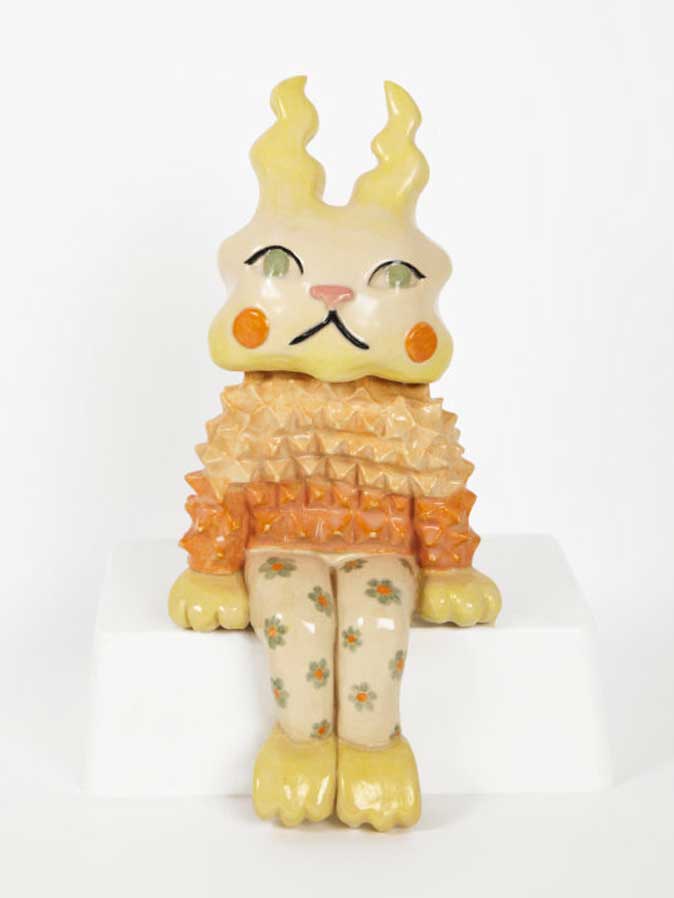 figura decorativa de un gato sentado sobre un fondo blanco